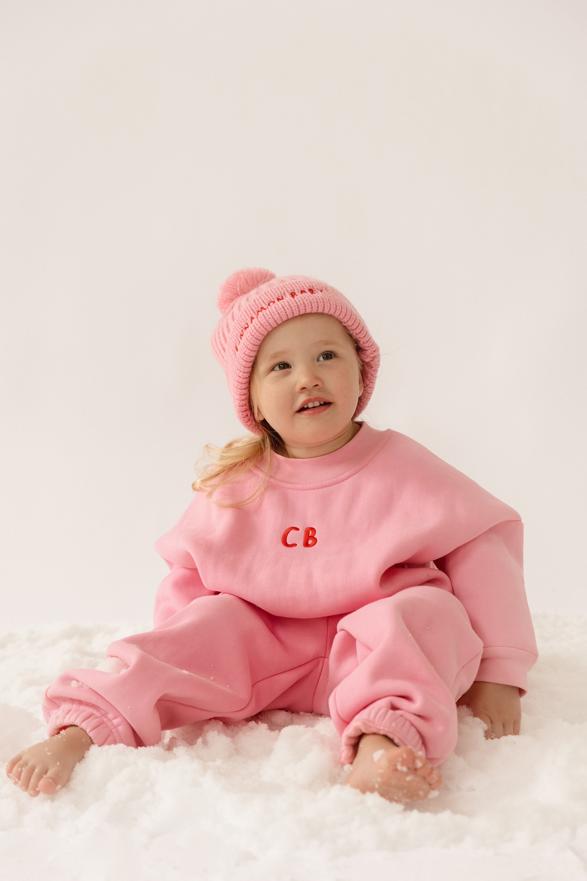 Cinnamon baby tracksuit with fairy floss pink accents, soft cotton blend unisex toddler outfit for comfy everyday wear.